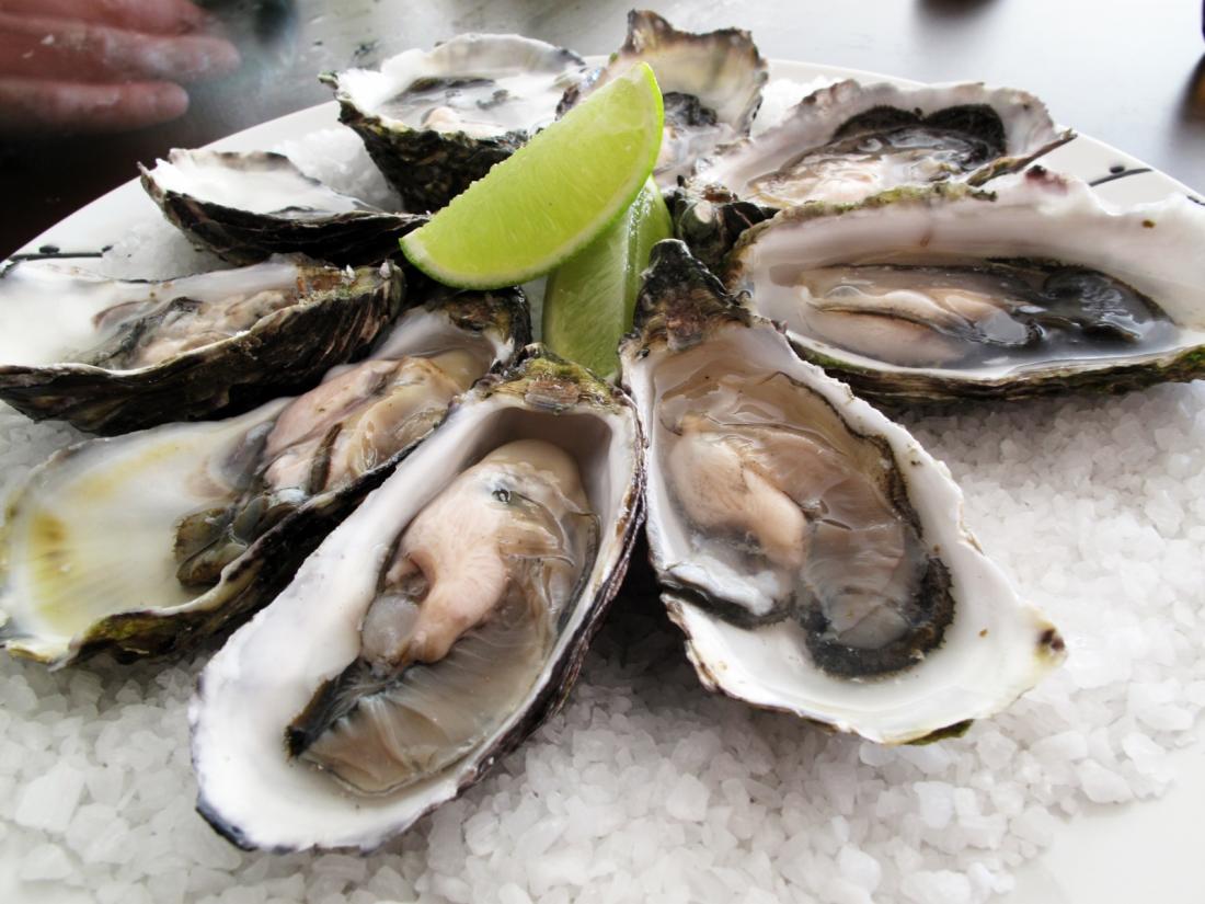 Shucked oysters displayed with a wedge of lime.