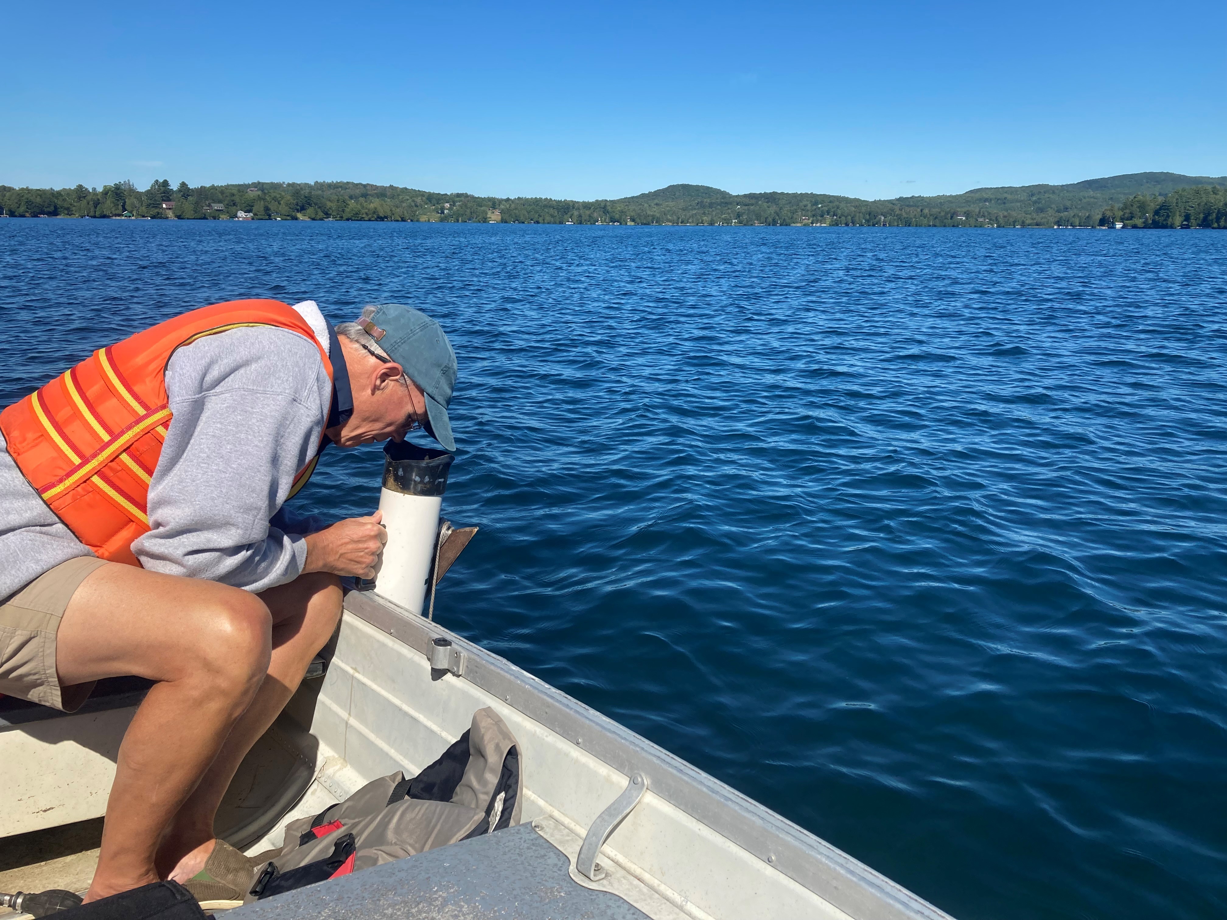 Man looking into the water over the edge of a boat