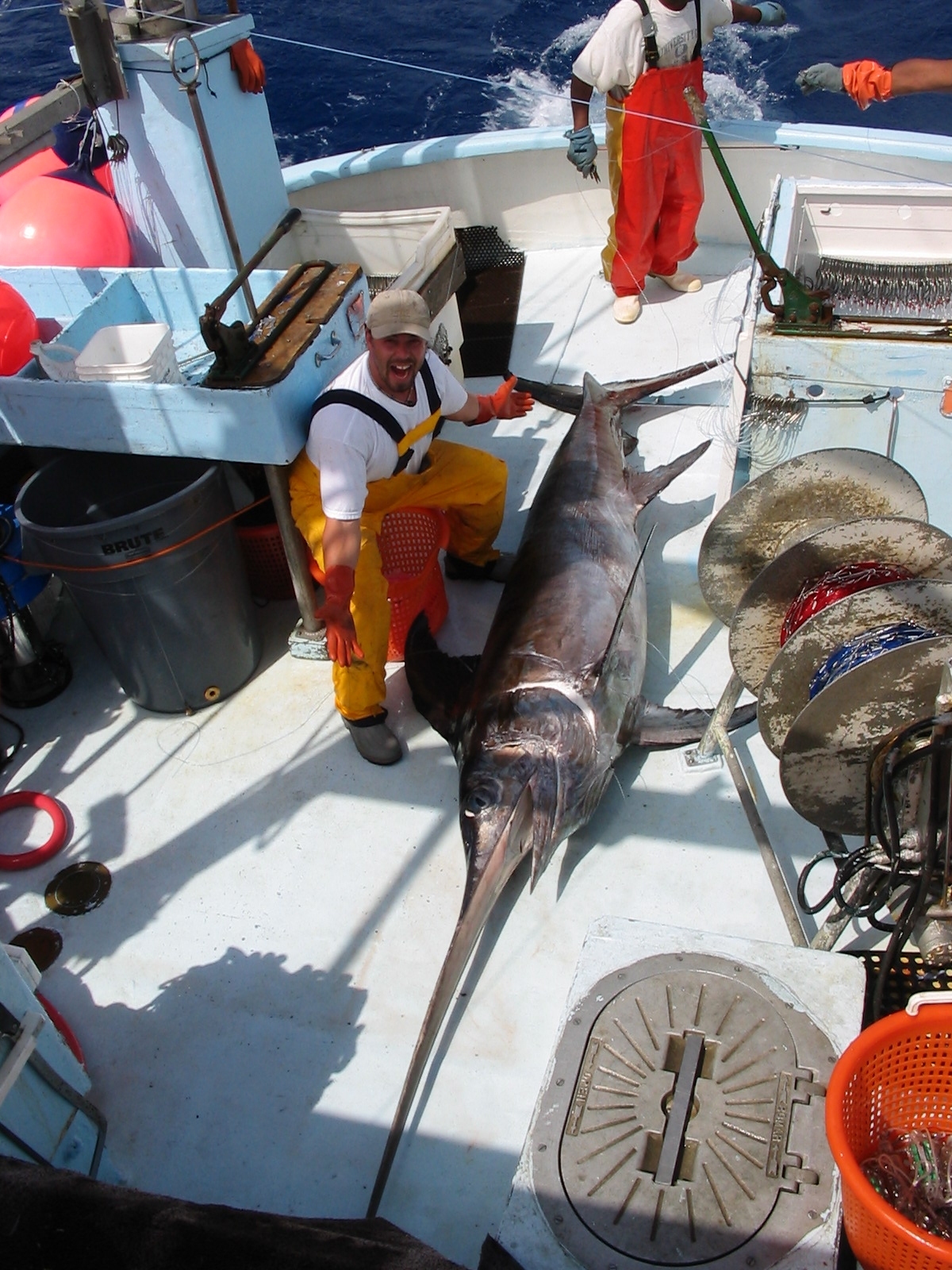 Derke Snodgrass/Wikipedia A fisherman poses with a swordfish on boat deck