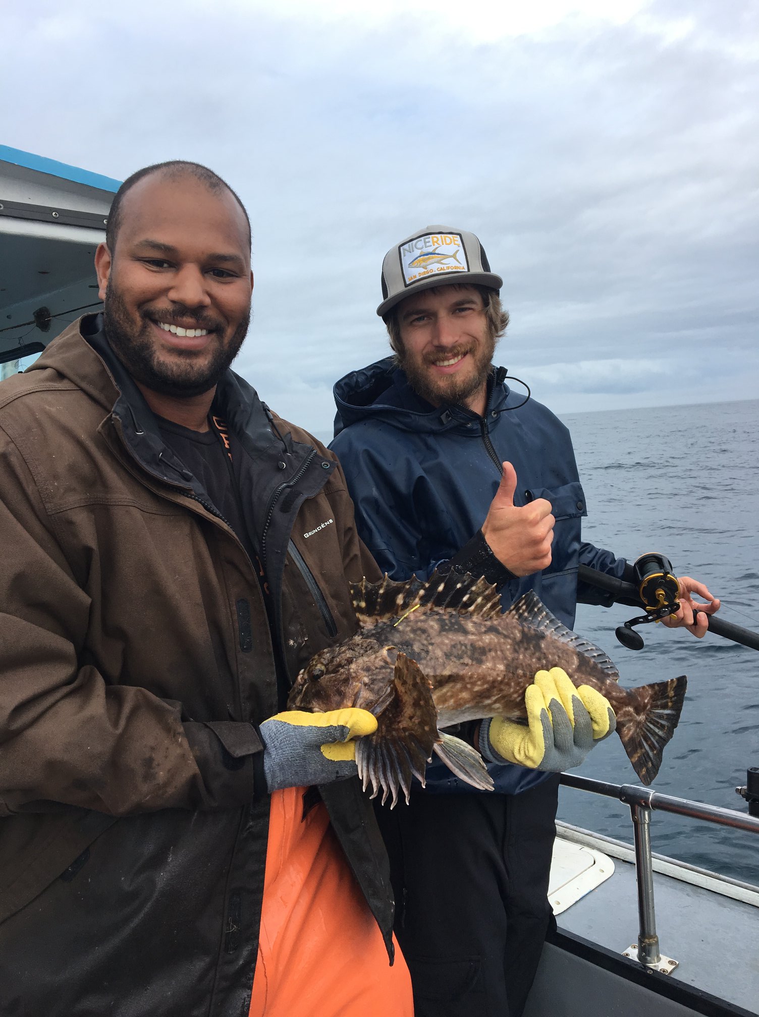 Fishermen display a brilliant rockfish caught while fishing with the CCFRP group. All fish are released after the researchers collect data on their size and location. 
