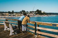 Two people fishing off a public pier. Courtesy of iStock.