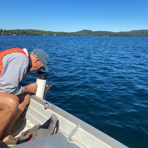 Man looking into the water over the edge of a boat