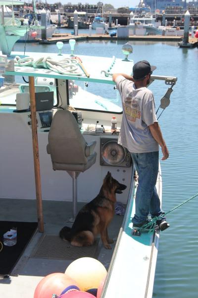 Fisherman standing on side of boat.