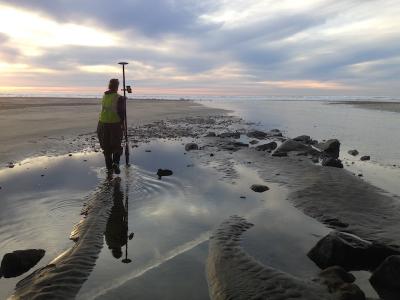 A researcher conducts a topographic and bathymetric survey at the mouth of Los Penasquitos Lagoon