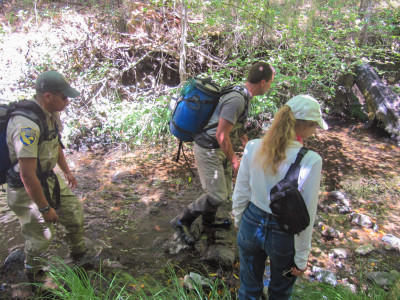 Landowner Nancy Summers (right) assists members of the coho broodstock team on her property