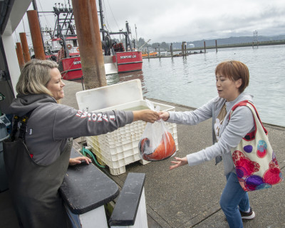 vendor handing customer a bag of fish