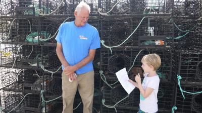 Fisherman being interviewed by girl.