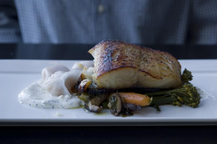 sablefish on a bed of broccolini, mushrooms, carrots, and cream sauce