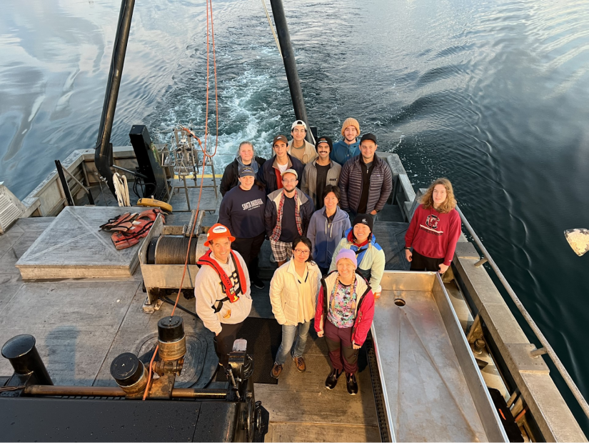 Valentine research team poses for a picture on the back of a ship.
