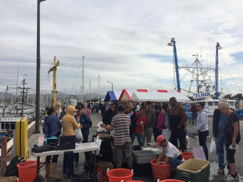 Customers inspect the offerings on the dock at a Ventura fish market.