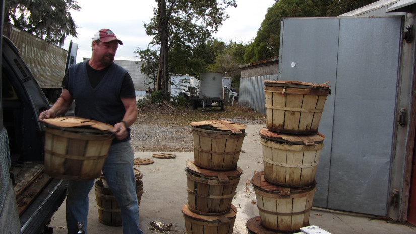 Man unloading barrels of seafood from trunk