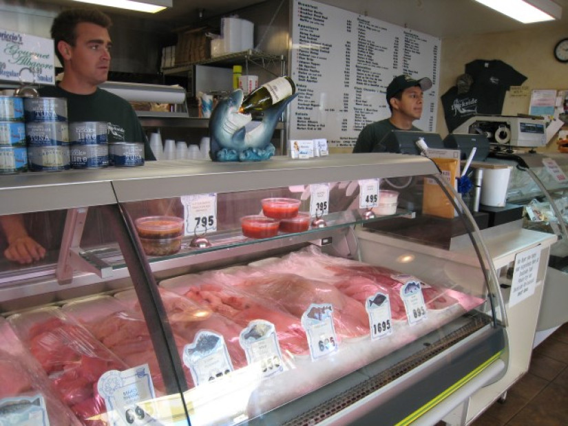 Refrigerated display case filled with seafood at retail market.
