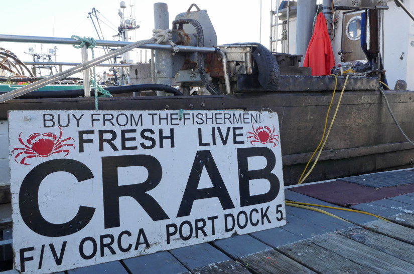 A sign advertises fresh crab for sale at a dock in Newport, Oregon