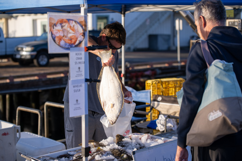 customer purchasing fish from vendor at santa barbara fishermen's market