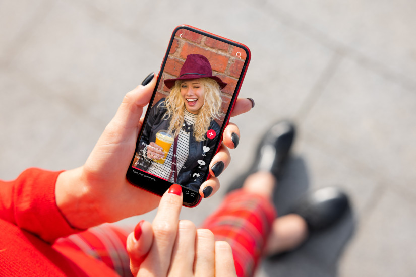 hands holding iphone that is open to tiktok