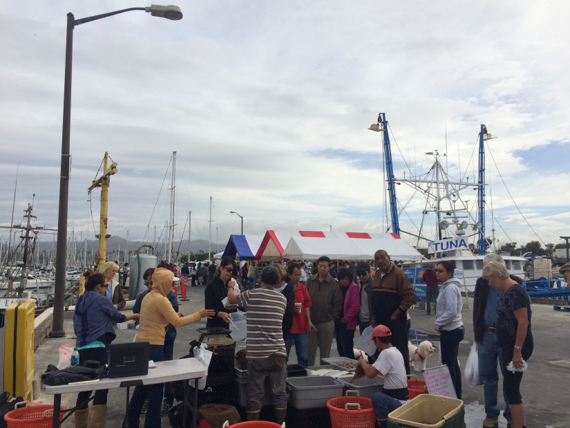 customers purchasing seafood from vendor
