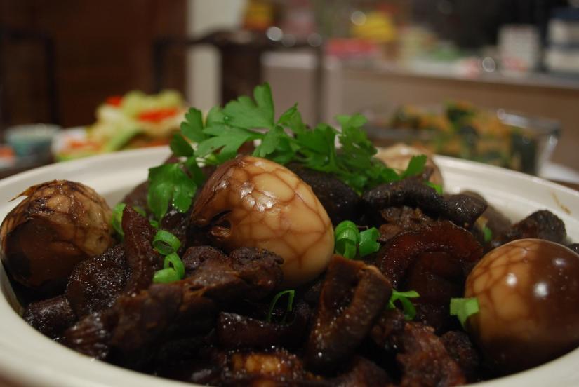 braised sea cucumbers with pork, mushrooms, eggs, and garnished with green onion and cilantro