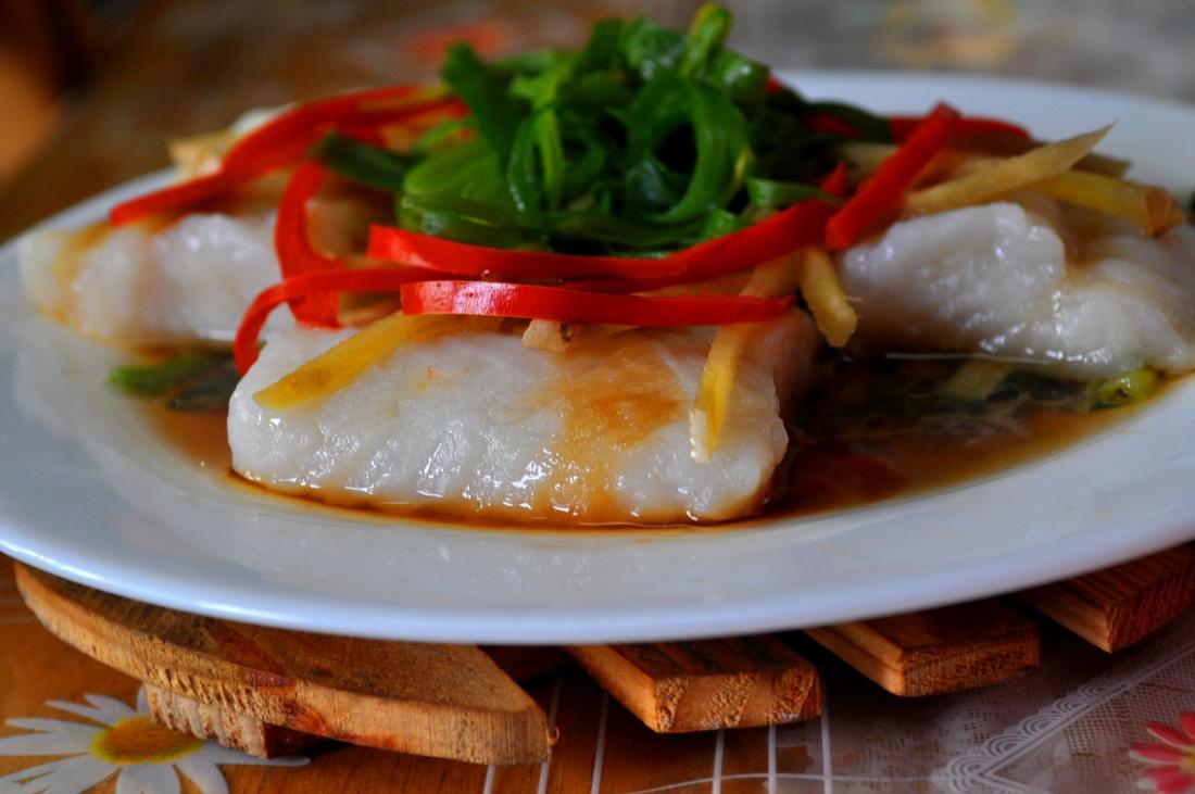 steamed fish with bell pepper and  green onion garnish and soy sauce