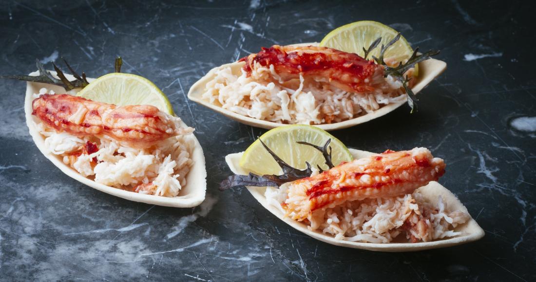 Cooked crab laid on decorative platters.