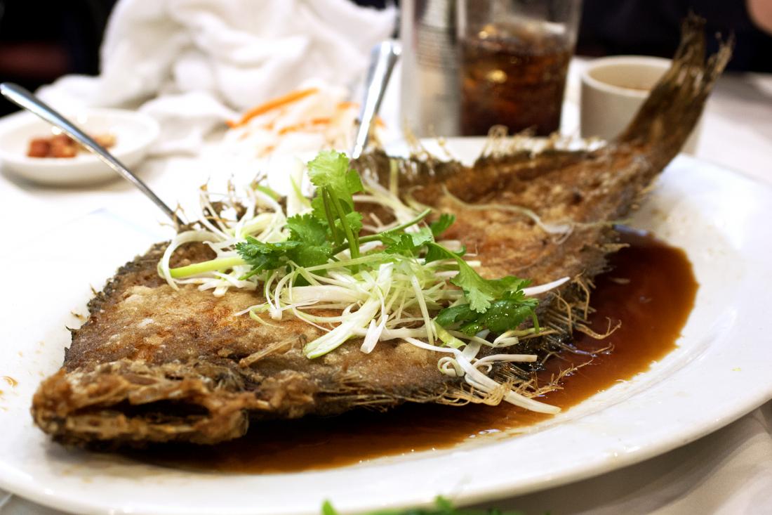 fried flounder with scallion and cilantro garnish and soy sauce