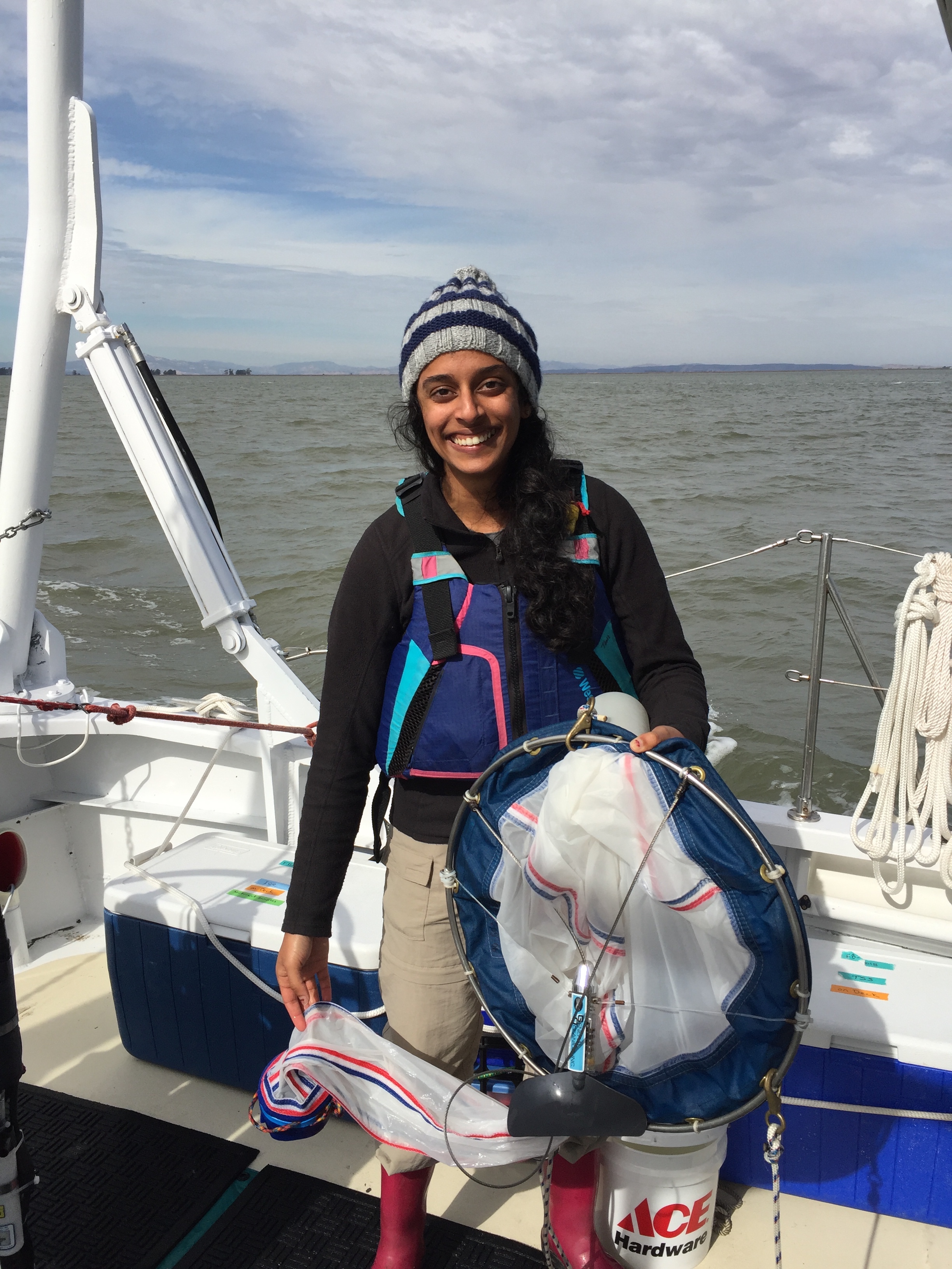 Cheryl Patel standing on a boat and holding a plankton net