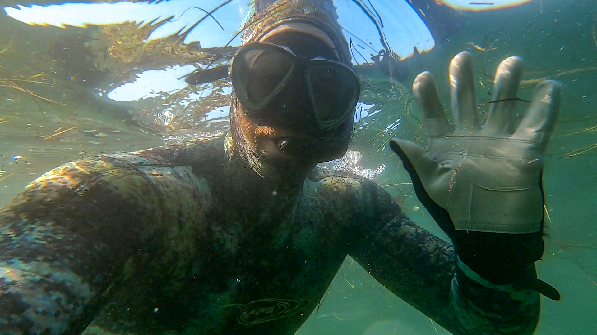 Snorkeler waving at camera underwater