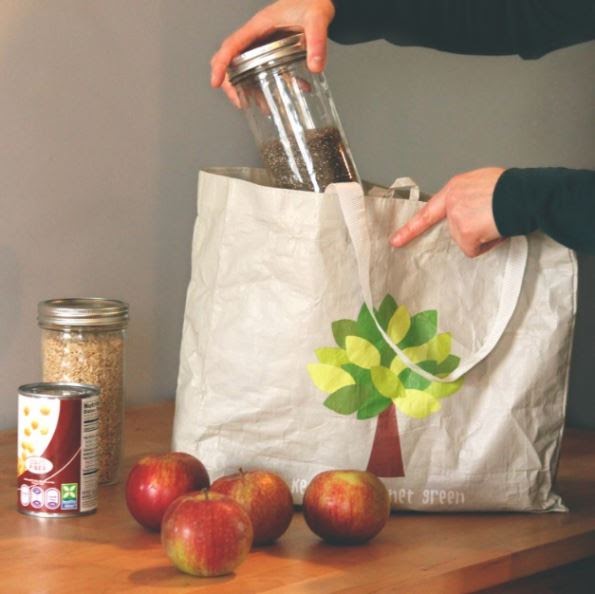 Jars of food being placed into reusable shopping bag