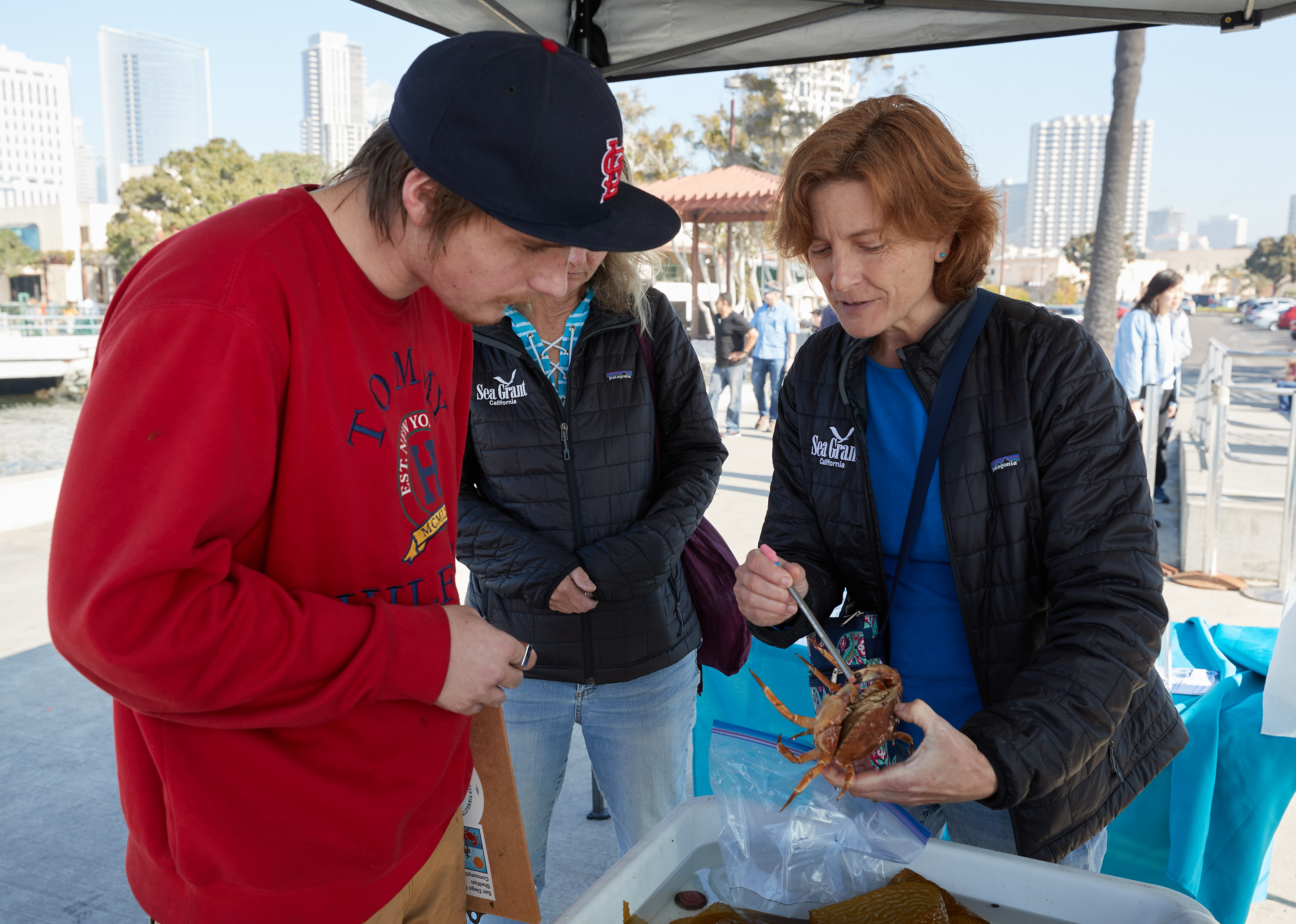 California Sea Grant Extension Specialist Theresa Talley showing an apprentice, Brandon, part of a crab.