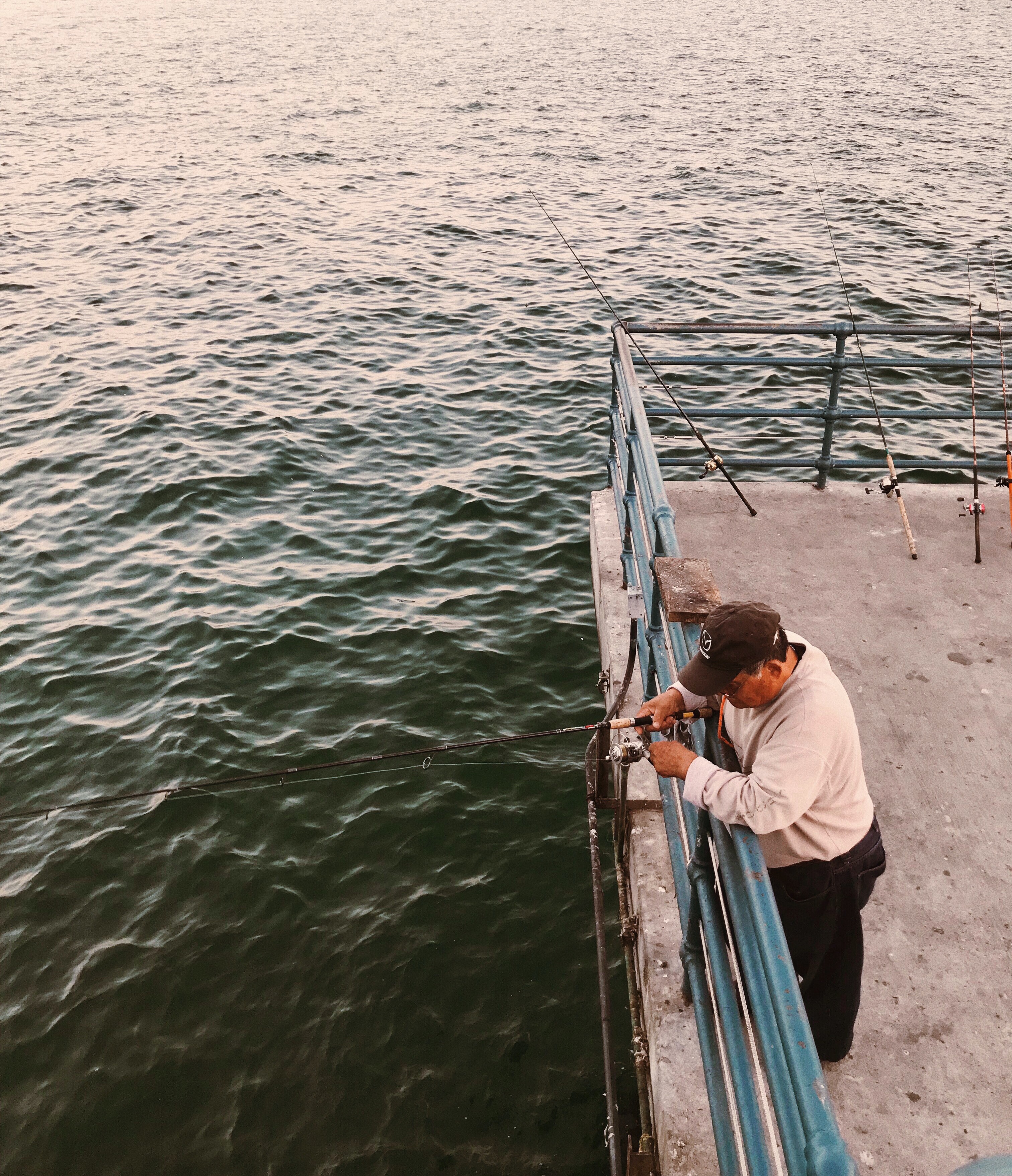 Man fishing off of a pier